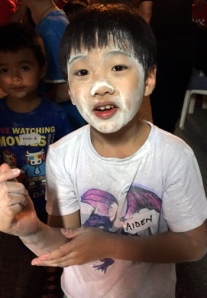 A flour-y face: A boy with his face covered with flour after picking letters out from a tray of flour in a game organised by the Singapore Kindness Movement volunteers